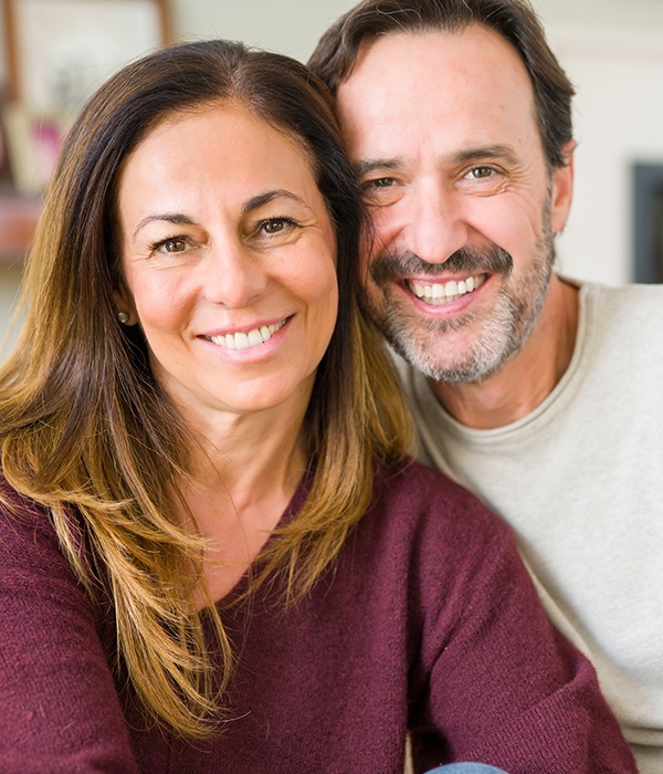 Man and woman with healthy smiles after crown lengthening