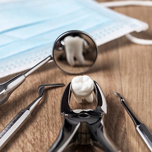 Tooth being held in a set of forceps