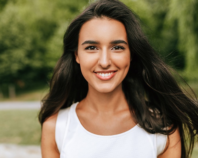 Young woman with healthy smile after gum disease therapy