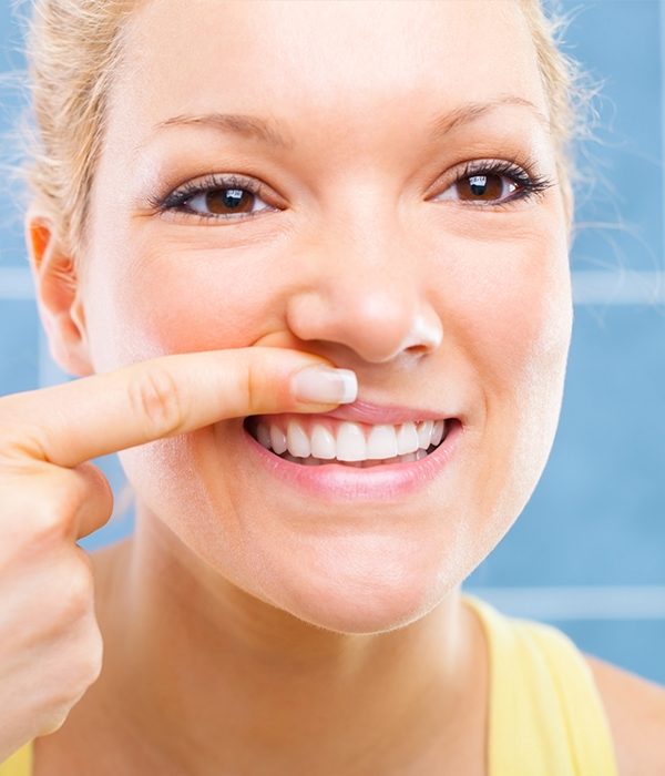 Woman looking at healthy soft tissue after gum disease treatment