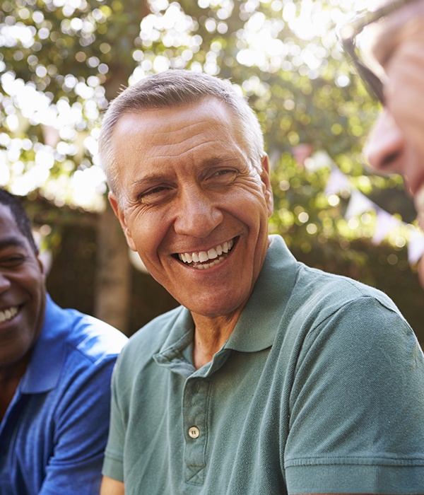 Older man smiling after gum disease treatment