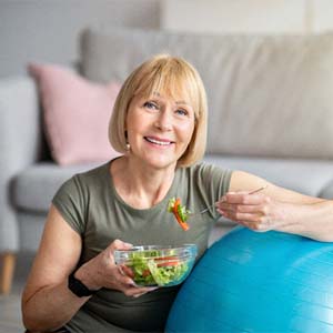 Woman eating a salad and smiling