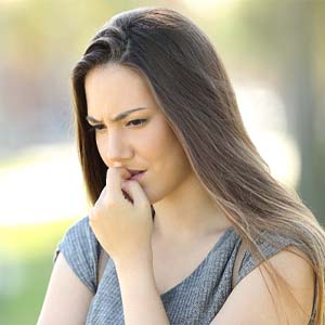 Woman biting her nails nervously