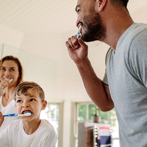 Family brushing their teeth together