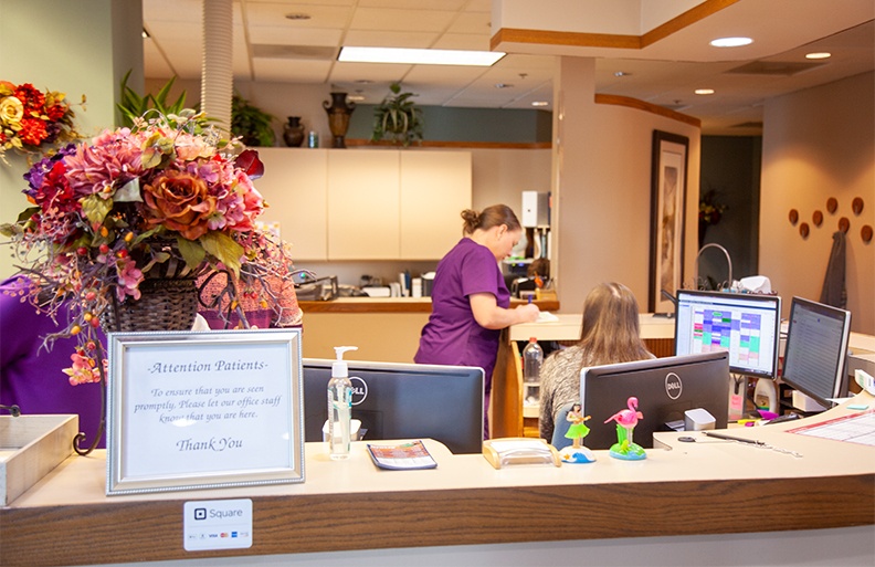 Two periodontal office team members behind reception desk