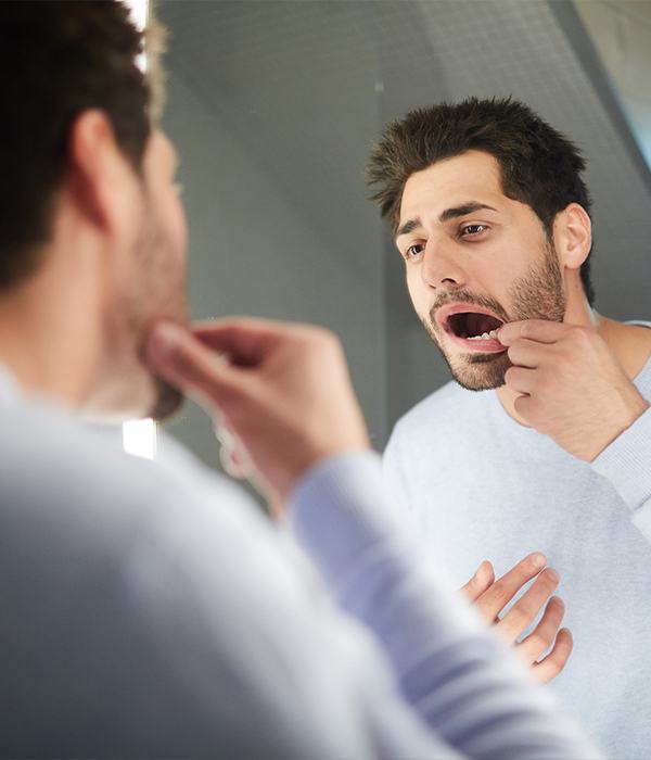 Man in need of tooth extraction looking at smile