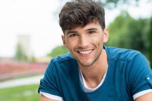 A young man smiling outside.