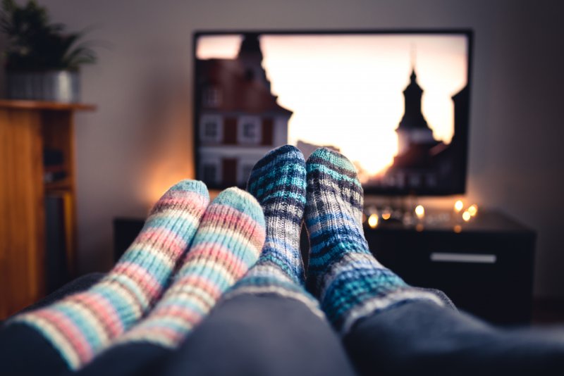 Couple watching TV on couch during holidays