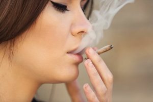 a person smoking a marijuana cigarette